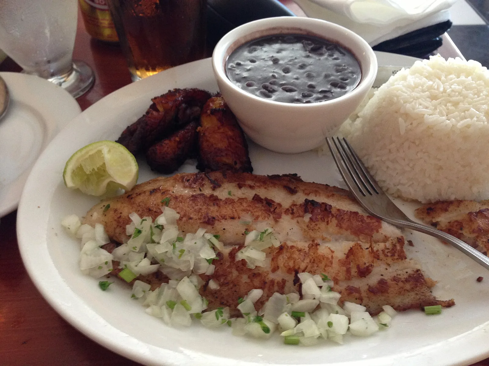 A Cuban fish plate with black beans, rice and plantains at a Fort Lauderdale restaurant.